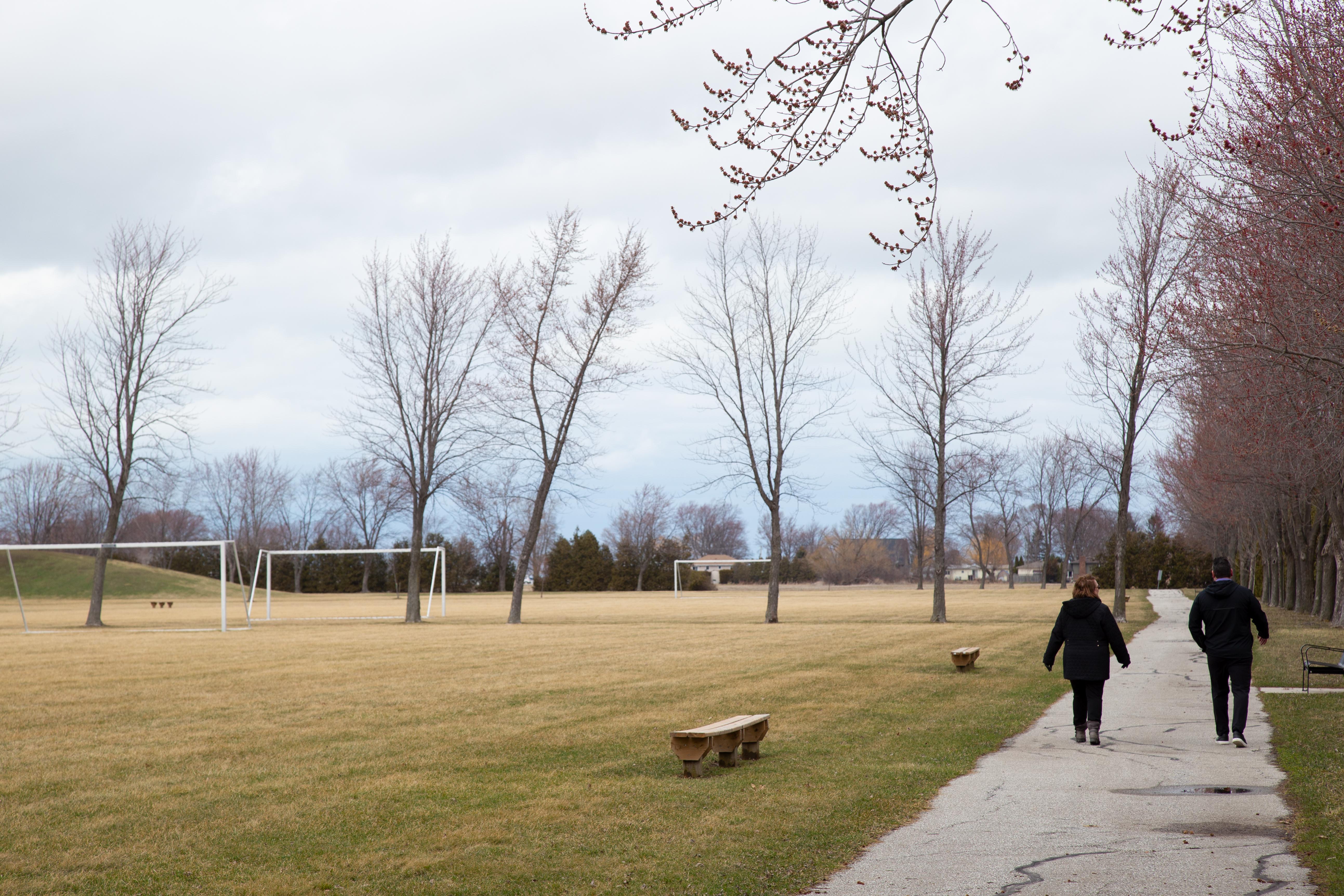 Two people walking down a path at Stoney Point Community Park.