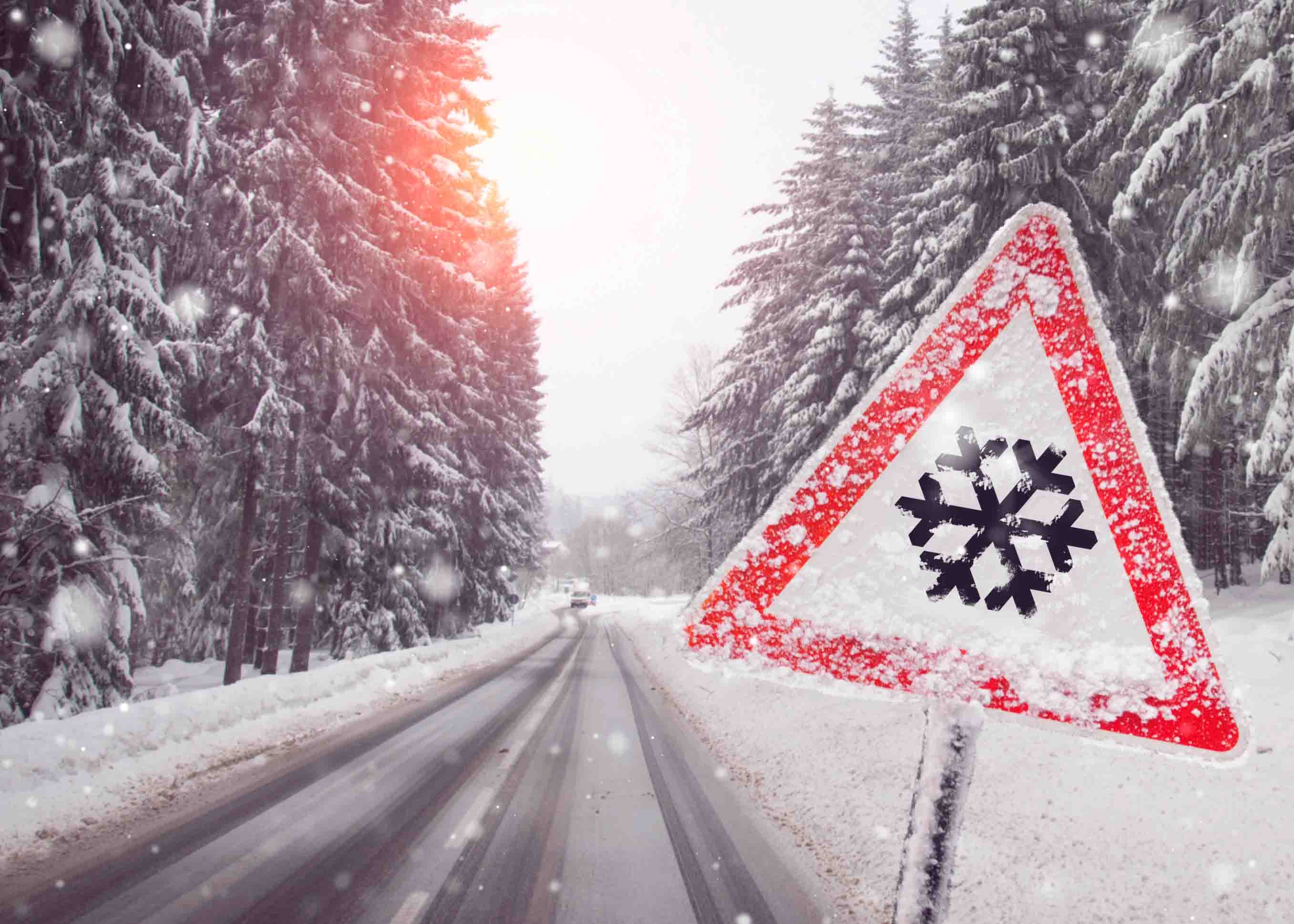 Image of snow warning sign on a snowy road.