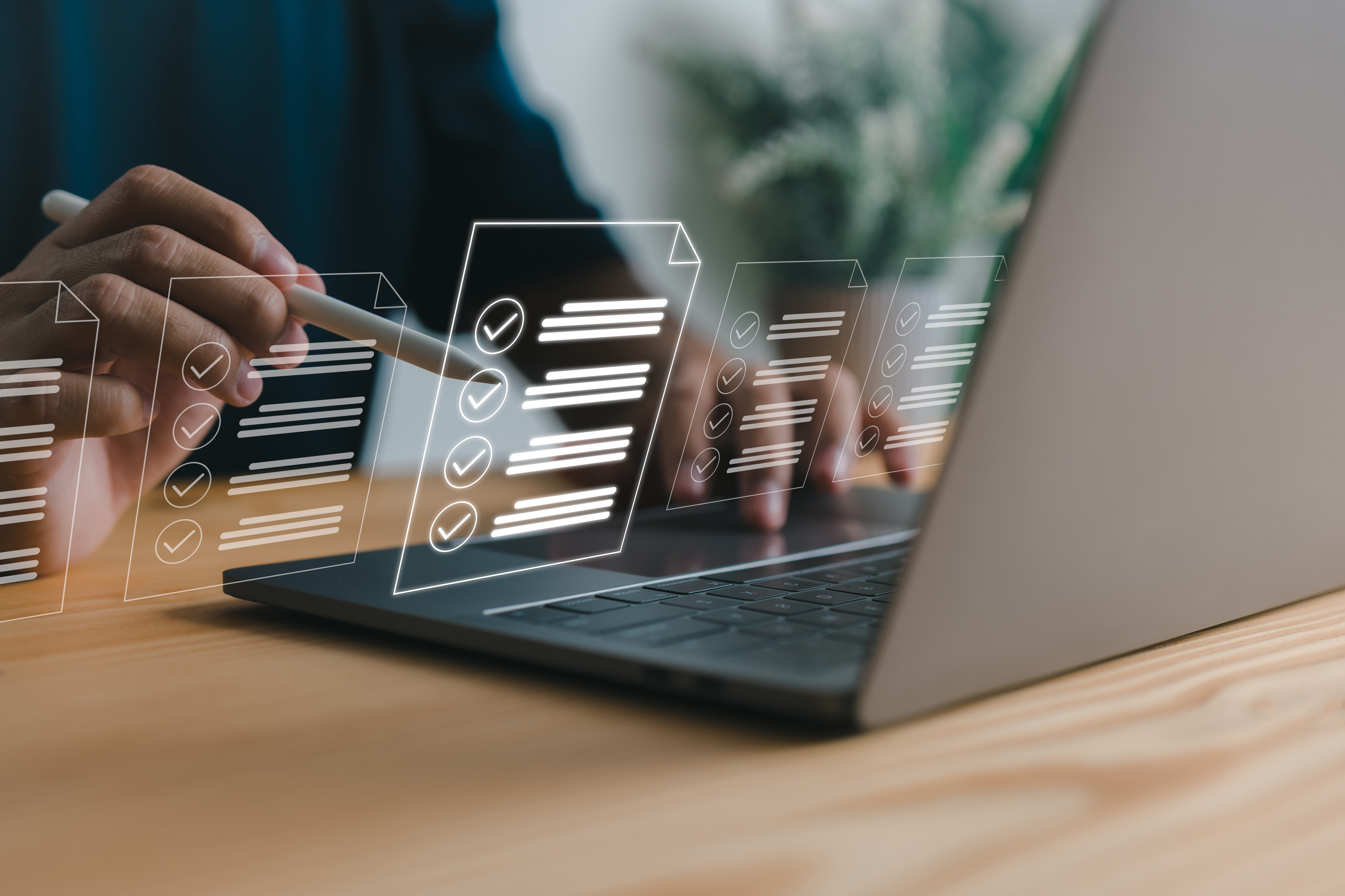 Person at a laptop with an overlay of digital forms above.